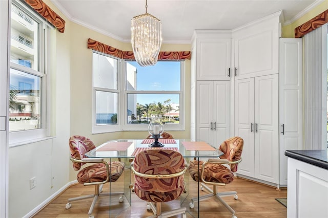 dining space featuring a notable chandelier, light hardwood / wood-style floors, and crown molding