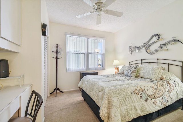 bedroom featuring ceiling fan, light colored carpet, and a textured ceiling