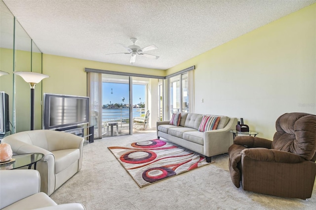 living room with light carpet, ceiling fan, and a textured ceiling