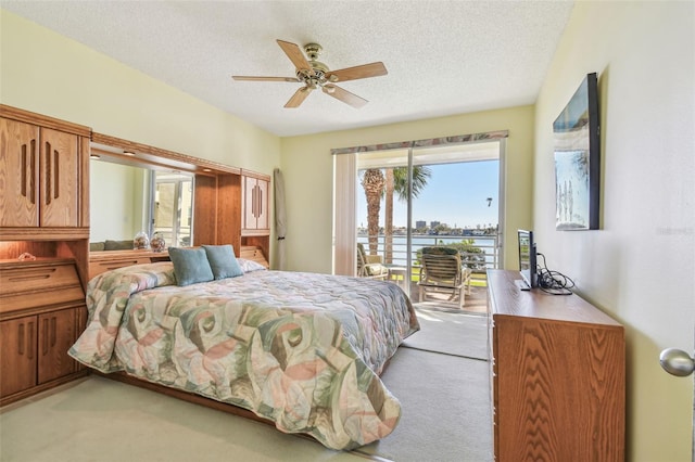 bedroom with access to outside, light carpet, ceiling fan, and a textured ceiling