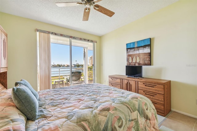 bedroom with access to exterior, light tile patterned floors, a textured ceiling, and ceiling fan