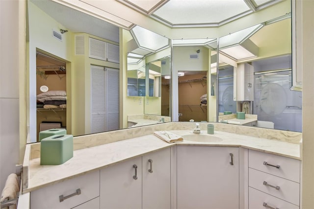 bathroom with vanity and a shower with door