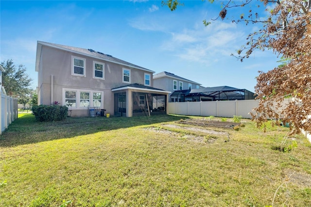 rear view of property with a yard and a sunroom