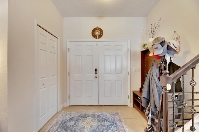 entrance foyer with light tile patterned floors and a textured ceiling