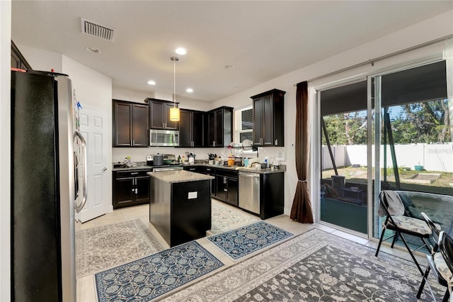 kitchen featuring decorative light fixtures, a center island, dark brown cabinets, and appliances with stainless steel finishes