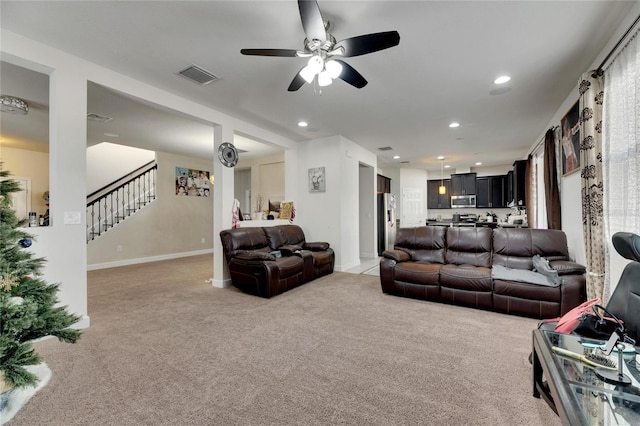 carpeted living room with ceiling fan