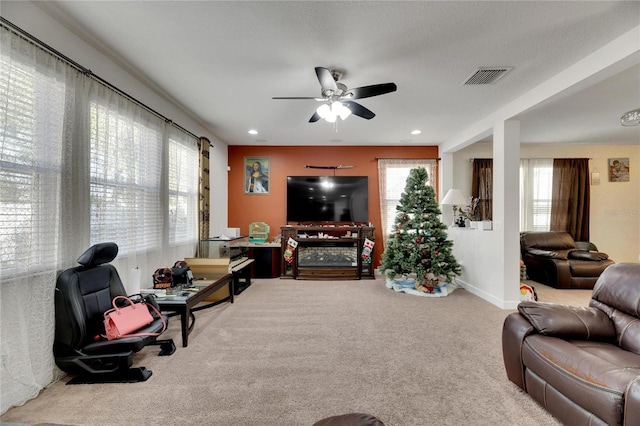 living room with carpet, ceiling fan, and a healthy amount of sunlight