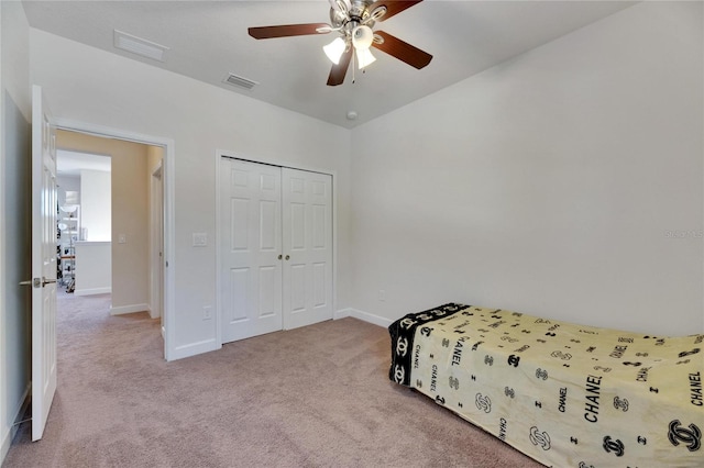 carpeted bedroom featuring ceiling fan and a closet