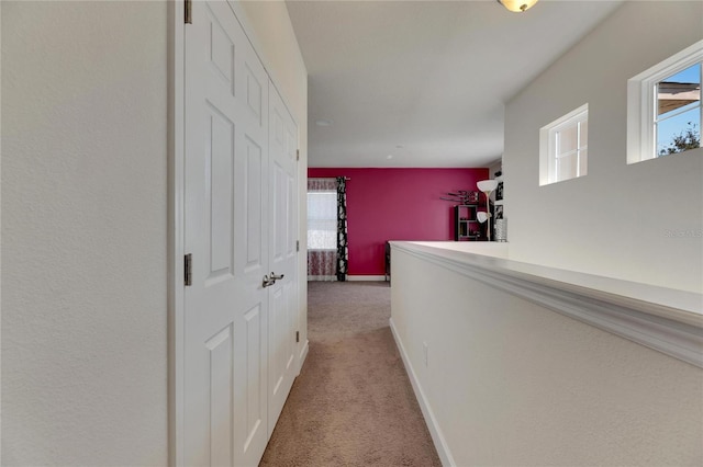 corridor with light colored carpet and plenty of natural light