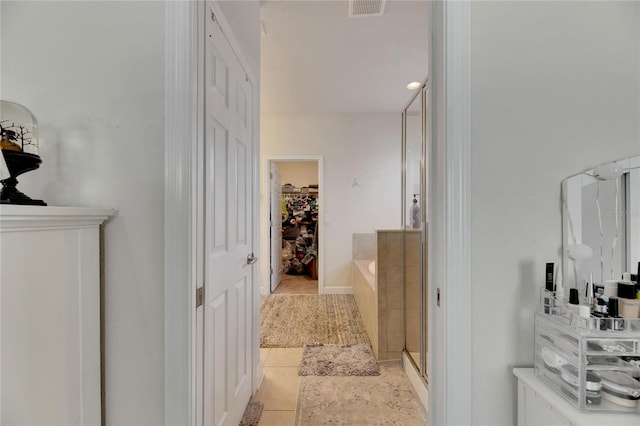 hall featuring light tile patterned floors