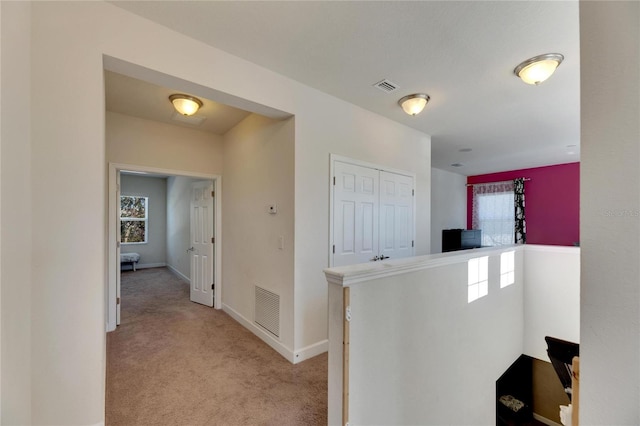 hall featuring light colored carpet