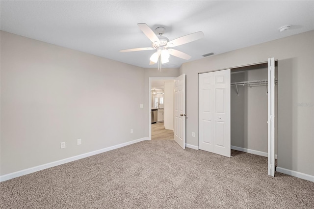 unfurnished bedroom featuring light carpet, a closet, and ceiling fan