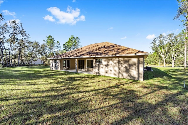 rear view of property with a yard and a patio