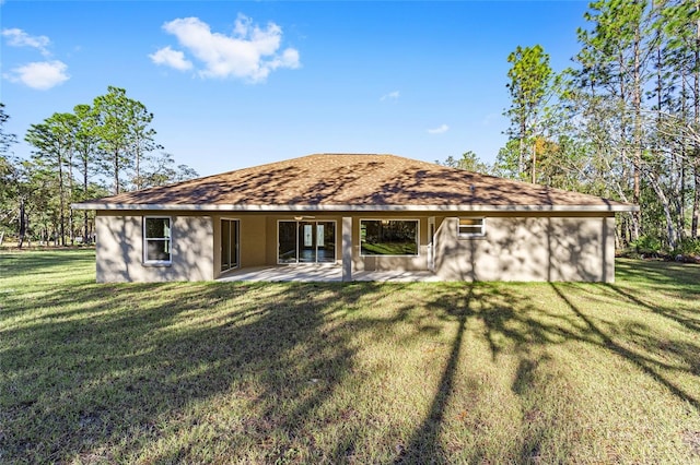 rear view of house featuring a patio and a lawn