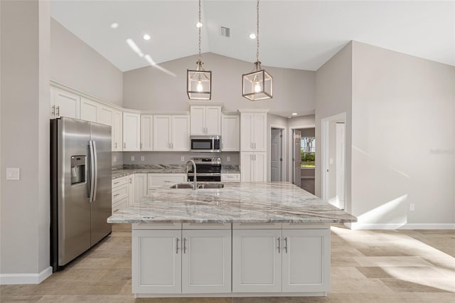 kitchen with high vaulted ceiling, white cabinetry, stainless steel appliances, and a kitchen island with sink