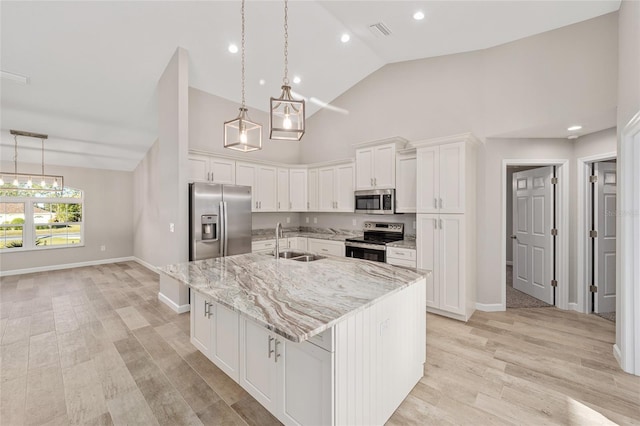 kitchen featuring a kitchen island with sink, white cabinets, sink, light wood-type flooring, and stainless steel appliances