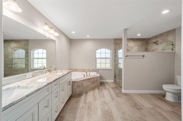 full bathroom featuring wood-type flooring, toilet, a wealth of natural light, and independent shower and bath