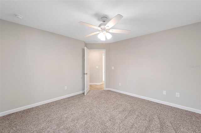 carpeted spare room with ceiling fan