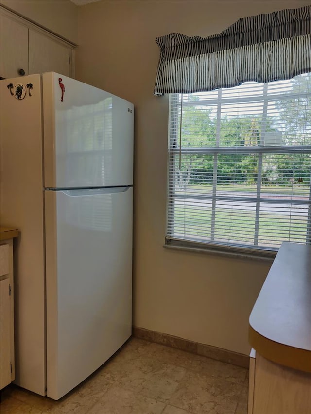 kitchen with white cabinets and white fridge