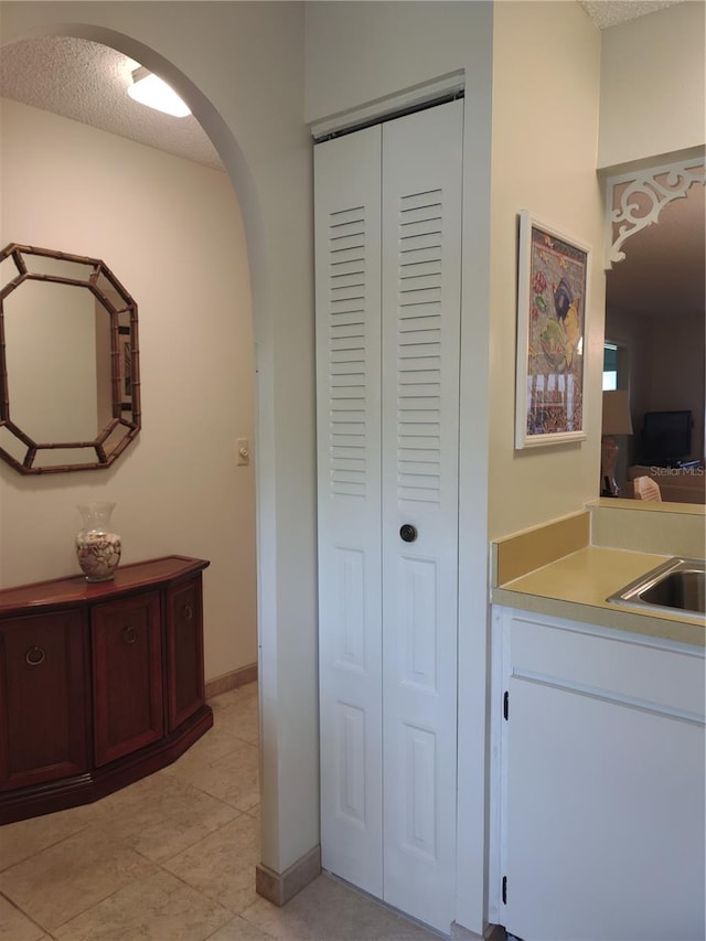 bathroom featuring tile patterned flooring, sink, and a textured ceiling