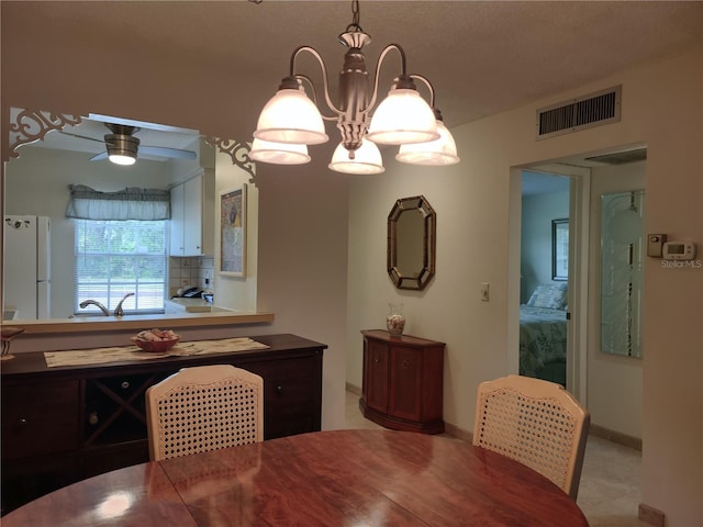 dining area featuring ceiling fan with notable chandelier