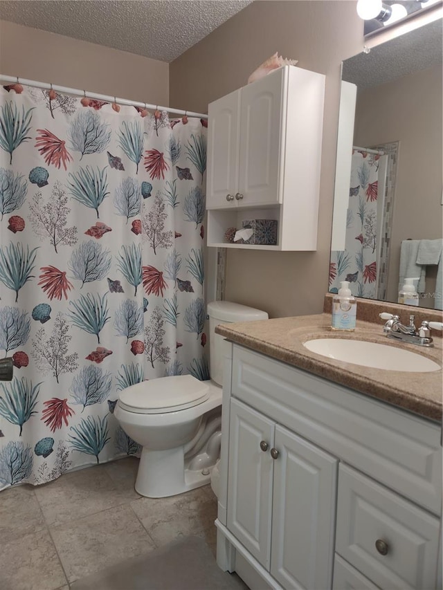 bathroom with vanity, tile patterned floors, a textured ceiling, and toilet