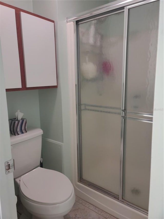 bathroom featuring tile patterned floors, walk in shower, and toilet