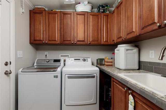 laundry room featuring washer and dryer, cabinets, and sink