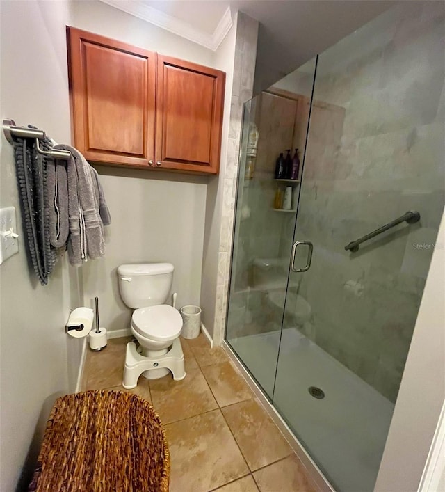 bathroom with tile patterned floors, toilet, an enclosed shower, and ornamental molding