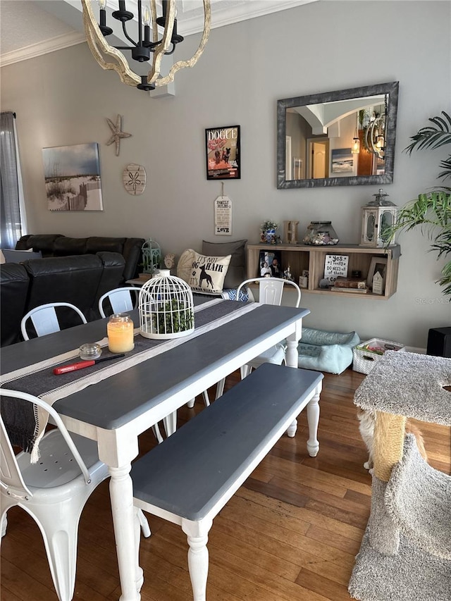 dining space featuring crown molding, hardwood / wood-style floors, and a notable chandelier