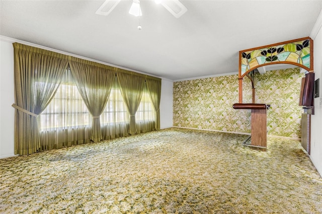 unfurnished living room with a wealth of natural light, crown molding, and ceiling fan