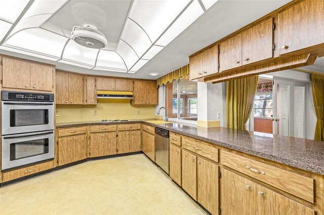 kitchen featuring dark stone counters, french doors, sink, tasteful backsplash, and stainless steel appliances