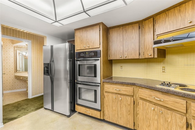 kitchen featuring tasteful backsplash, range hood, and appliances with stainless steel finishes