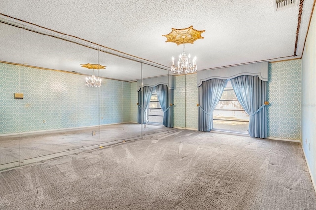 carpeted empty room featuring a textured ceiling and crown molding