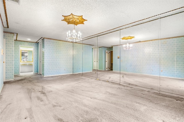 carpeted empty room with a textured ceiling and ornamental molding