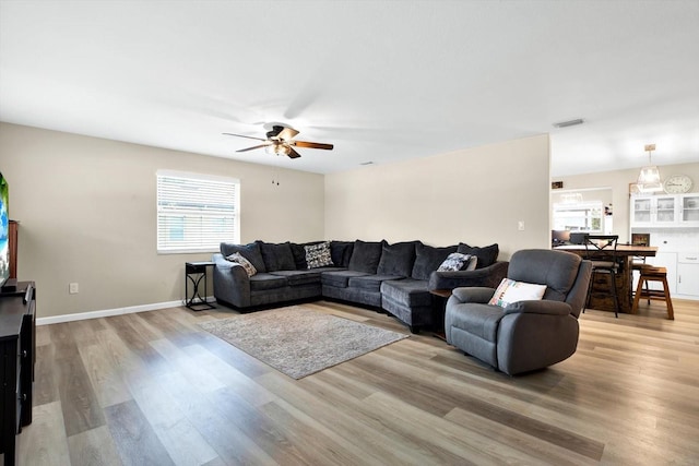 living room with light hardwood / wood-style flooring and ceiling fan