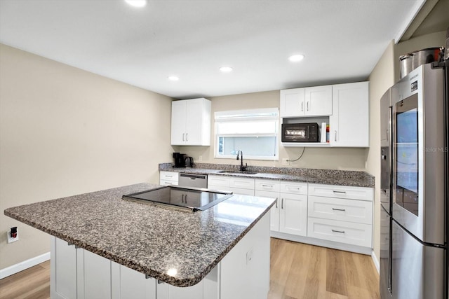 kitchen featuring white cabinets, sink, a breakfast bar, and black appliances