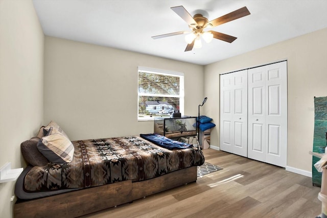 bedroom featuring ceiling fan, a closet, and light hardwood / wood-style flooring