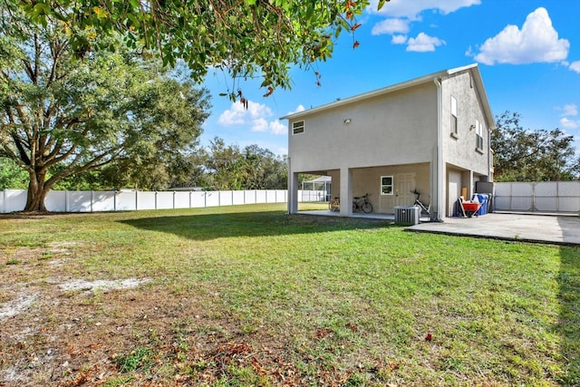 back of property with a patio area, a yard, and central air condition unit