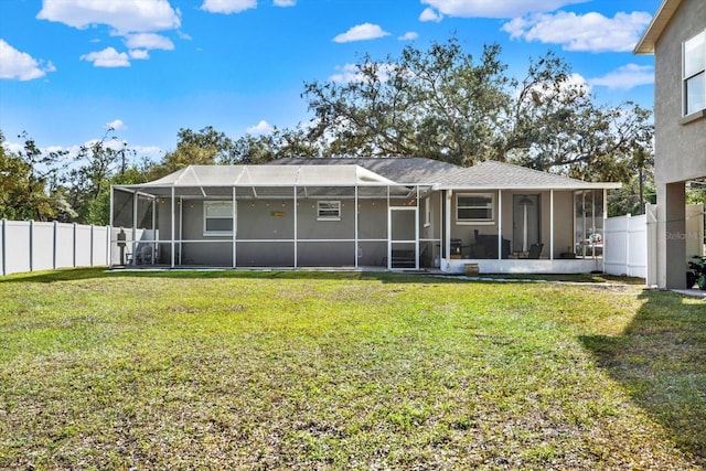 back of property with a lanai and a lawn