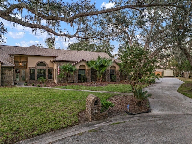 ranch-style home featuring an outbuilding, a garage, and a front lawn