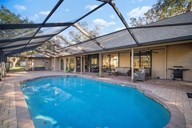 view of pool with an outdoor living space, ceiling fan, a lanai, area for grilling, and a patio area