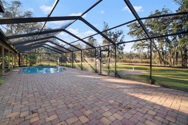 view of swimming pool with a lawn, glass enclosure, and a patio area