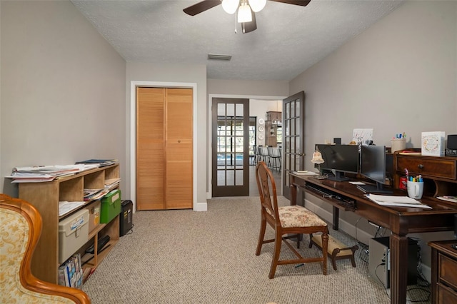 carpeted office space with ceiling fan, a textured ceiling, and french doors