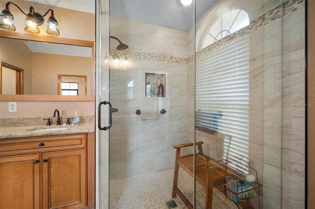 bathroom featuring vanity, a shower with door, and a textured ceiling