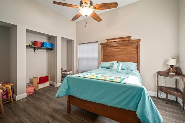 bedroom featuring ceiling fan, a closet, a towering ceiling, and dark hardwood / wood-style floors