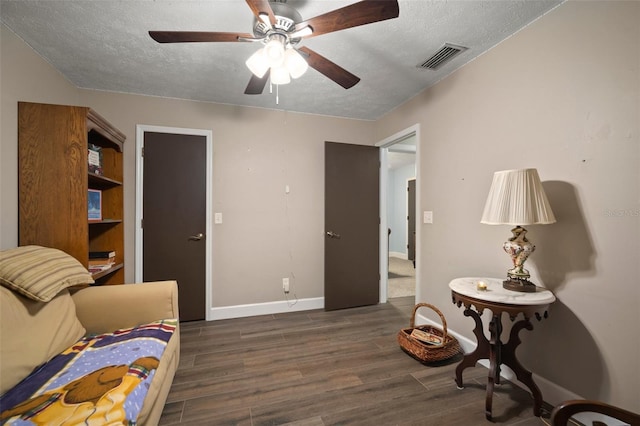 interior space featuring a textured ceiling, dark hardwood / wood-style flooring, and ceiling fan