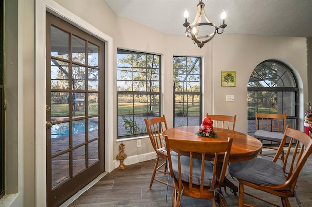 dining room with dark wood-type flooring, a textured ceiling, and an inviting chandelier