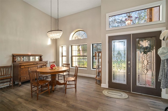 dining room with french doors, high vaulted ceiling, dark wood-type flooring, and an inviting chandelier