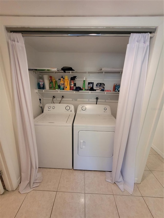 laundry room featuring washer and clothes dryer and light tile patterned floors